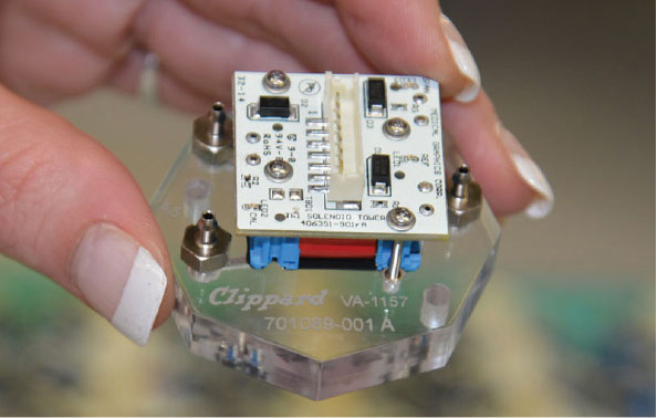 A hand holding a Clippard Custom Solution